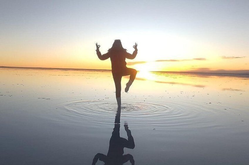 A person jumping on a reflective surface with a sunset in the background. 4