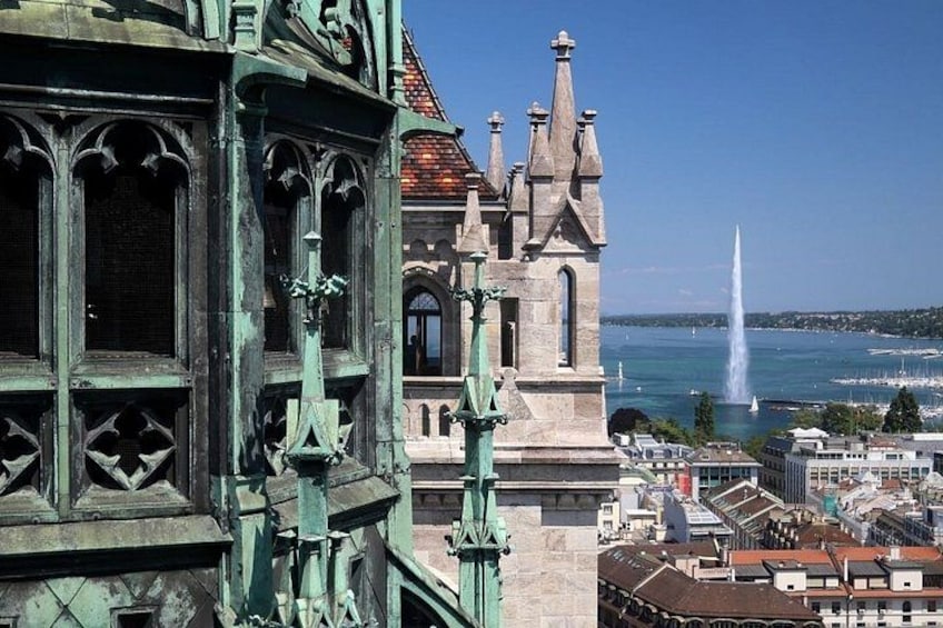 A historic building with ornate architecture, a fountain, and a clear view of a body of water. 2