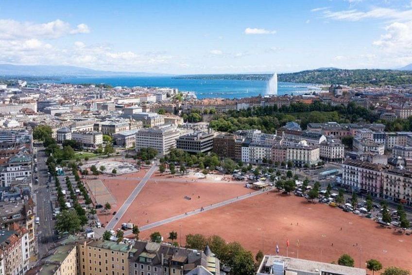 A cityscape with a large open square, historic buildings, and a body of water in the background. 3
