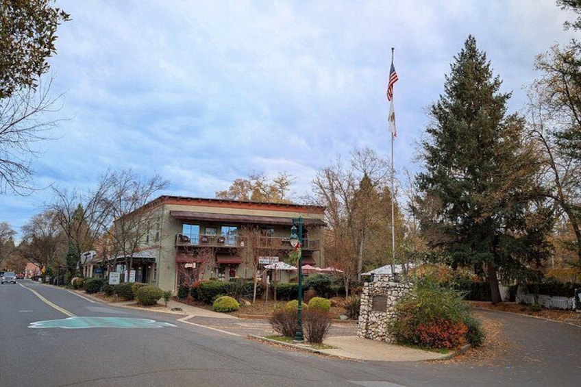 A building with a red roof, a flagpole with an American flag, and a road with a blue line marking. 1