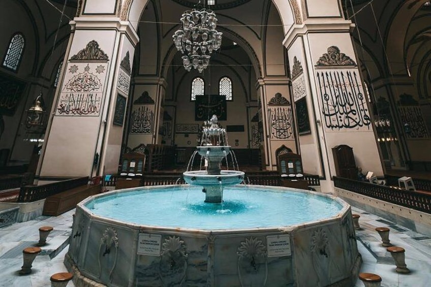 Una gran fuente ornamentada en una iglesia, con decoraciones intrincadas en las paredes y una araña. 5