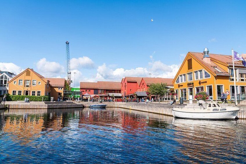 A waterfront with buildings, a boat docked, and a crane. 3