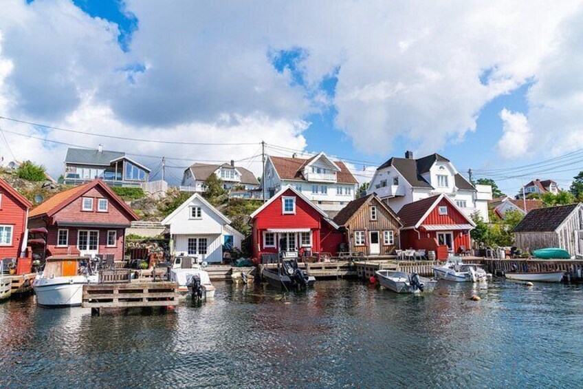 A harbor with red and white houses, boats, and a clear sky. 2