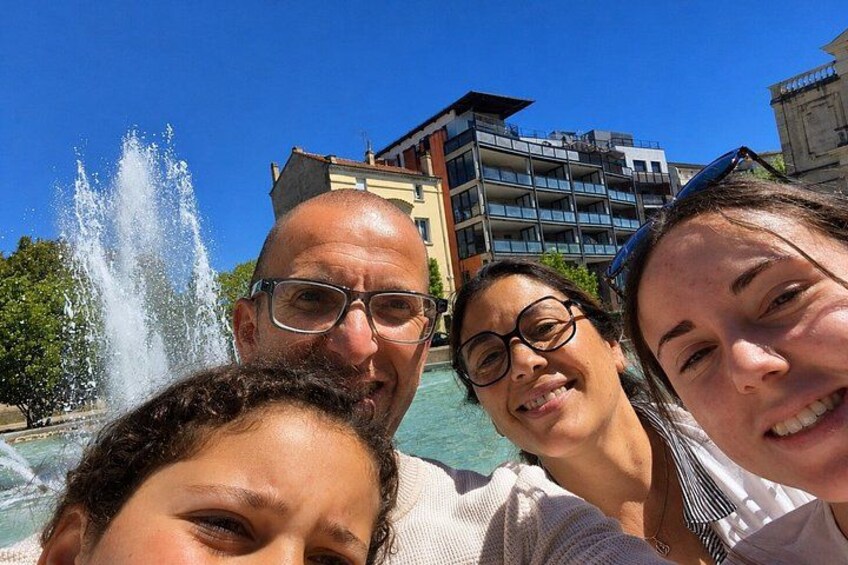 Un grupo de personas cerca de una fuente, con edificios al fondo. 5