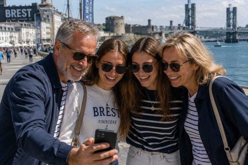 A group of people taking a selfie with a historic bridge and castle in the background. 3