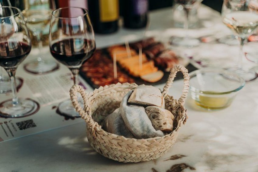 Un cesto di vimini con del pesce su un tavolo con bicchieri da vino e un menu. 5