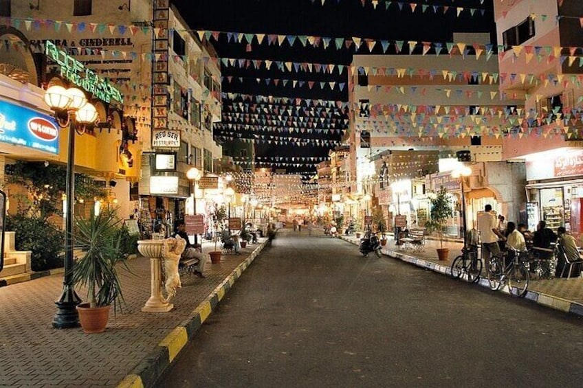 Una calle nocturna con tiendas y adornos colgantes. 1