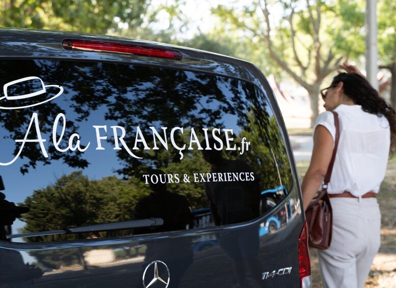 Un automóvil con un logotipo y texto que indica que es para tours y experiencias en Francia. 3