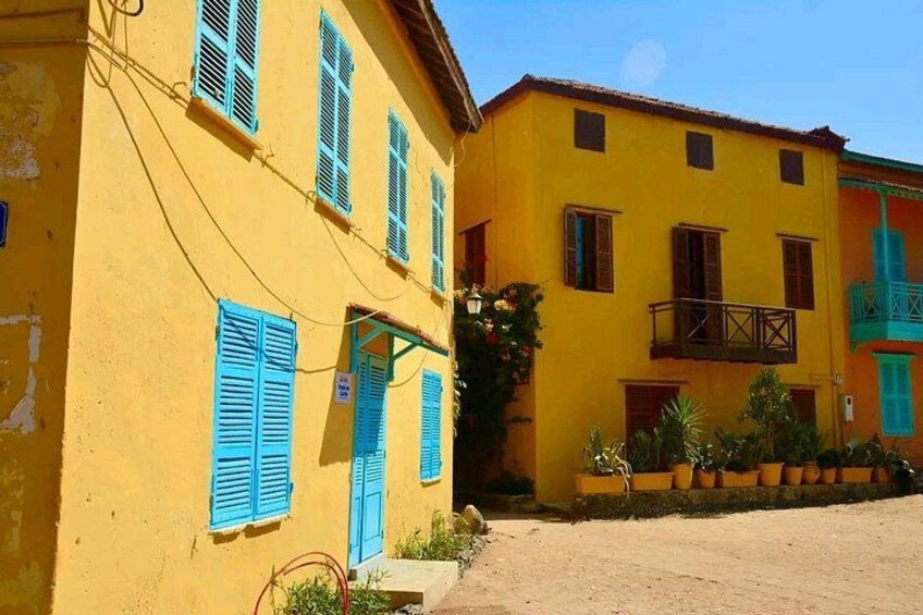 A yellow building with blue shutters and a balcony. 2