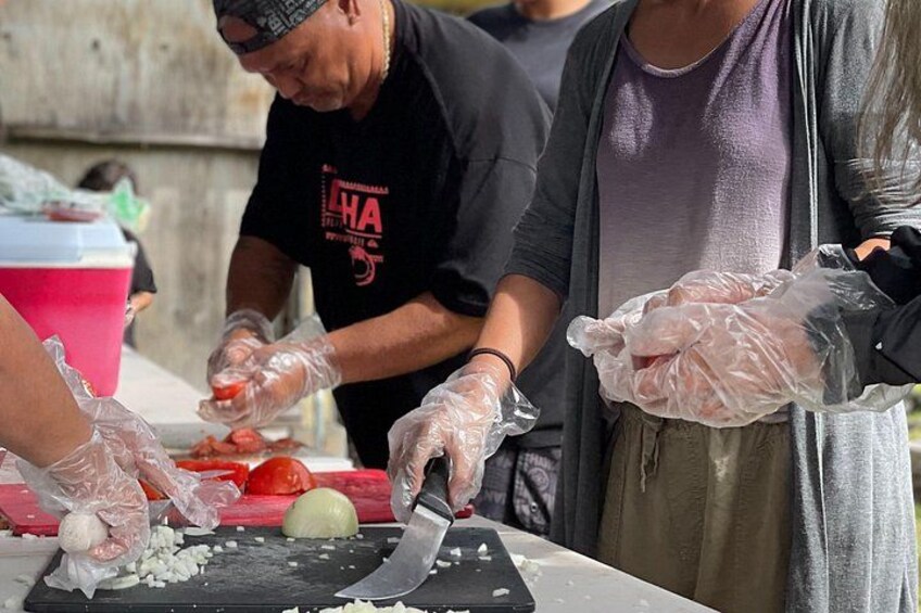 People preparing food, wearing gloves, and using a knife on a cutting board. 2