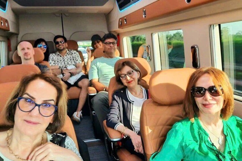 A group of people seated inside a vehicle with windows and a visible interior. 4