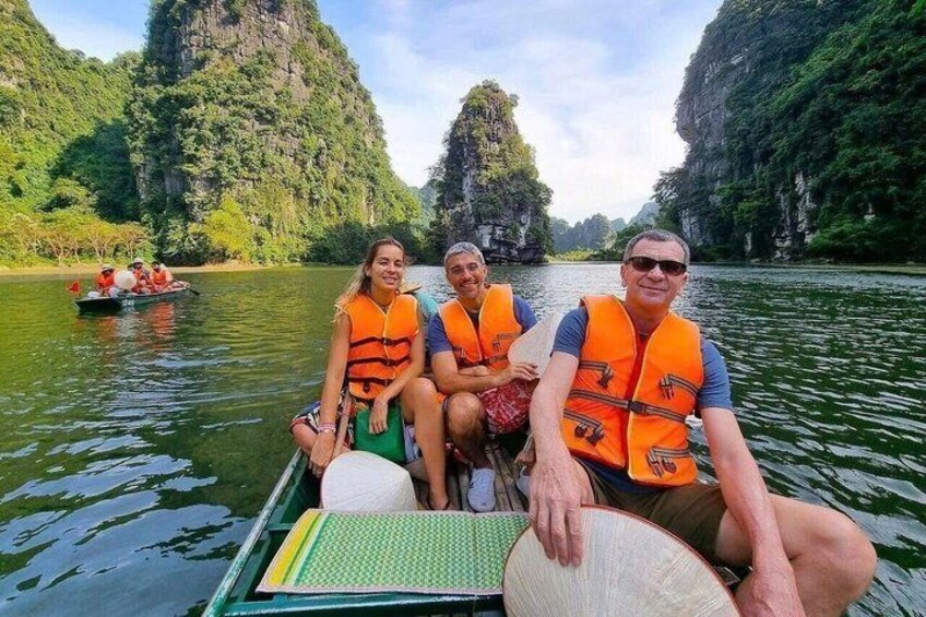 A group of people in a boat on a river surrounded by cliffs. 5