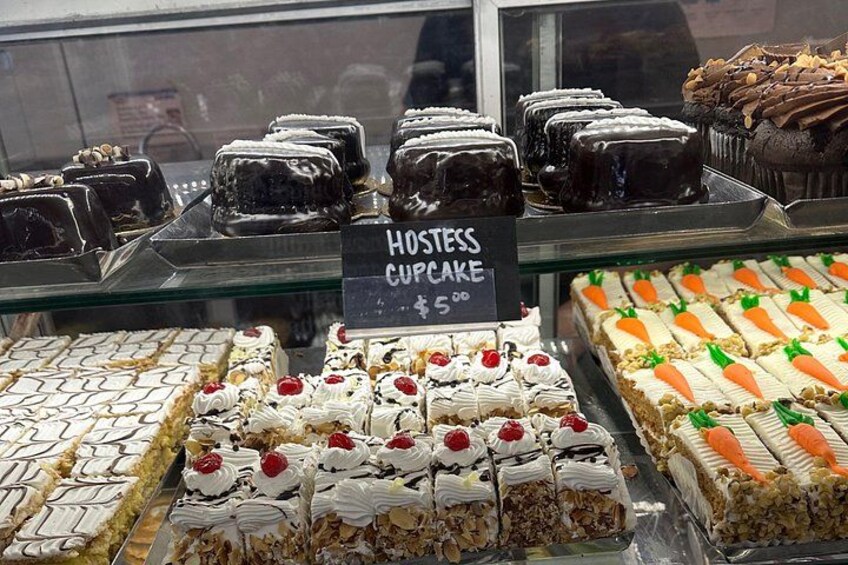 Une vitrine contenant divers desserts, dont un panneau indiquant le prix des « Hostess Cupcakes » à 5,00 $. 2