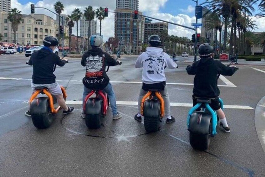 Four people riding Segways at an intersection. 4