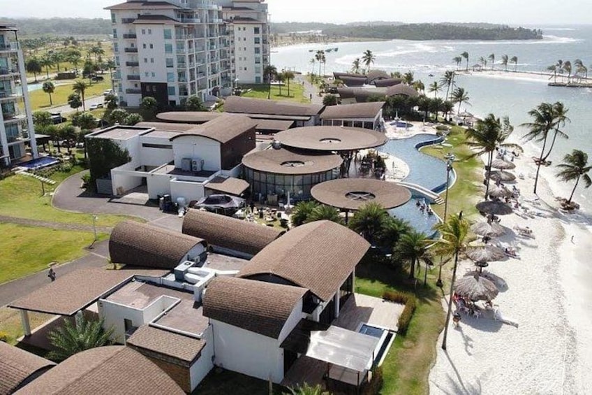 A resort with buildings, a pool, and a beach. 5