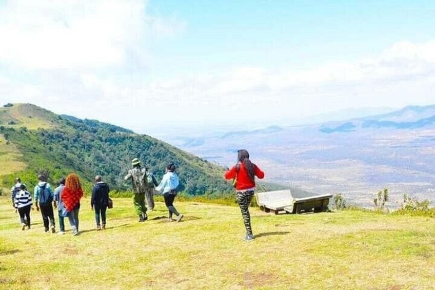 A group of hikers on a grassy hill with a view of distant mountains. 5