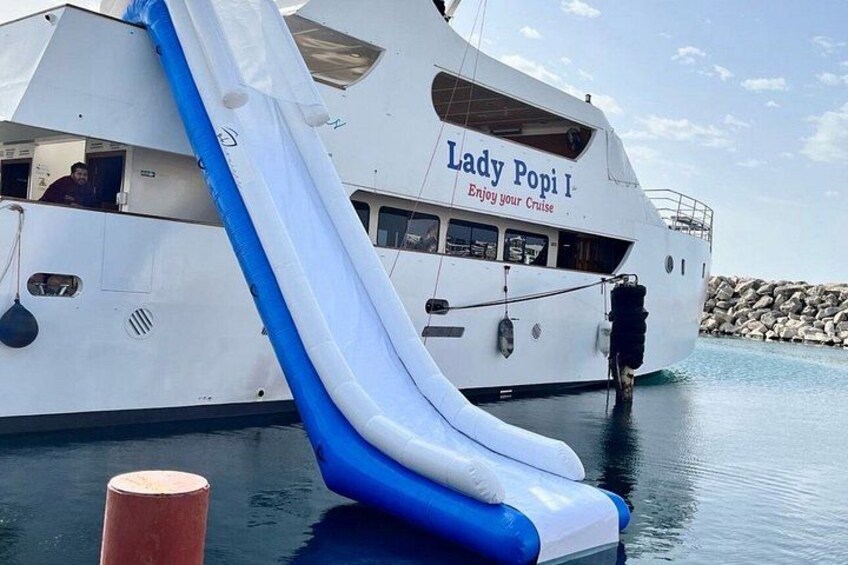 Un yate blanco llamado 'Lady Popi I' con un tobogán inflable azul y blanco. 4