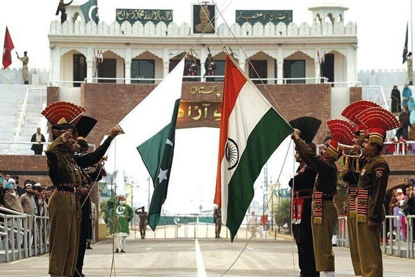 A ceremonial event with military personnel holding flags in front of a historic building. 2