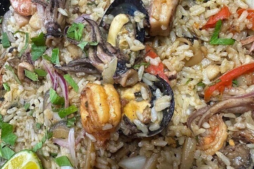 A dish of seafood paella with rice, mussels, shrimp, and vegetables. 2