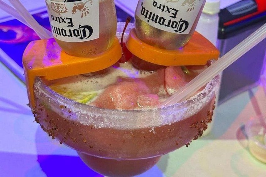 En margarita med saltad kant, isbitar och två sugrör. 3