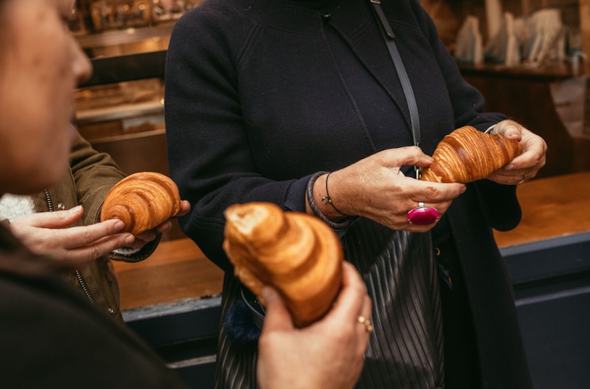 Two people holding croissants. 4