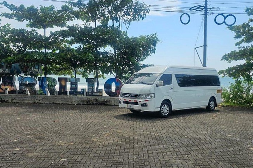 Una camioneta blanca estacionada frente a un letrero con la palabra 'ARRILLO'. 2