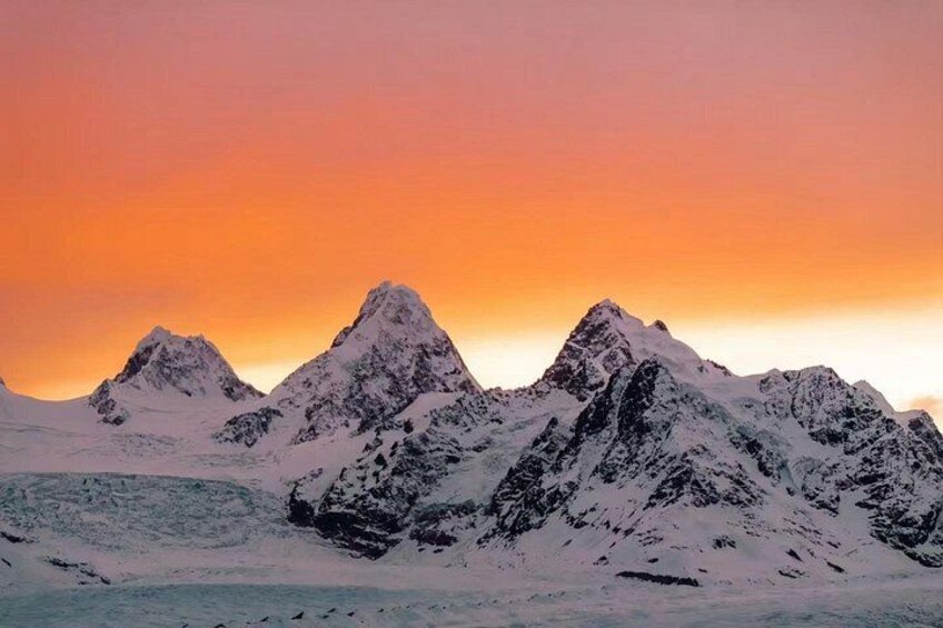 Snow-covered mountains under a sunset sky. 4