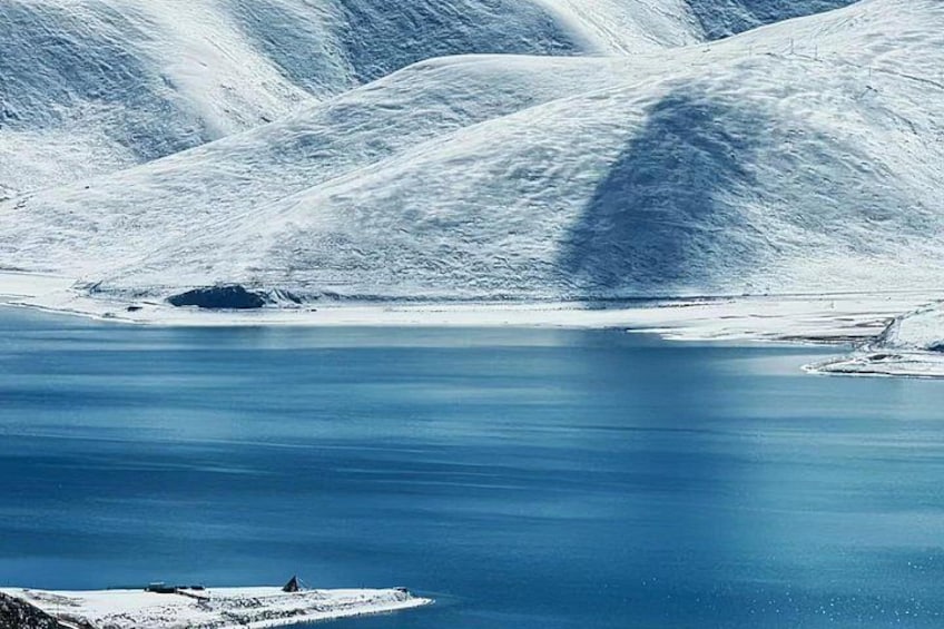 A calm, snow-covered lake surrounded by mountains. 2