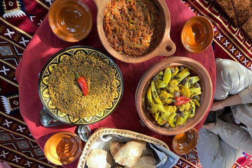 A variety of dishes on a table, including lentils, a vegetable stew, and bread. 3