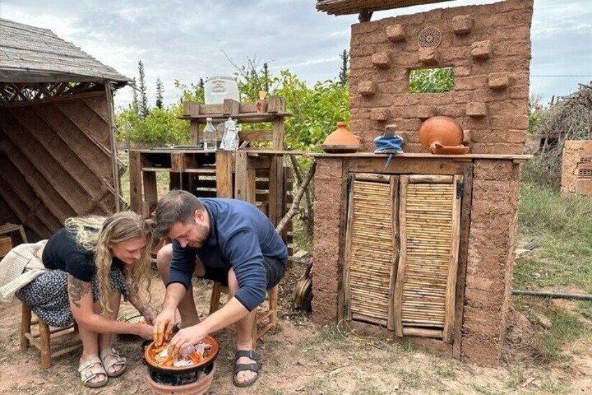 A rustic outdoor cooking setup with a brick oven, wooden structures, and a small garden. 1