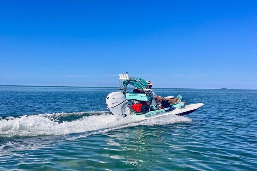 A speedboat with a blue canopy and a white hull on a calm sea. 2
