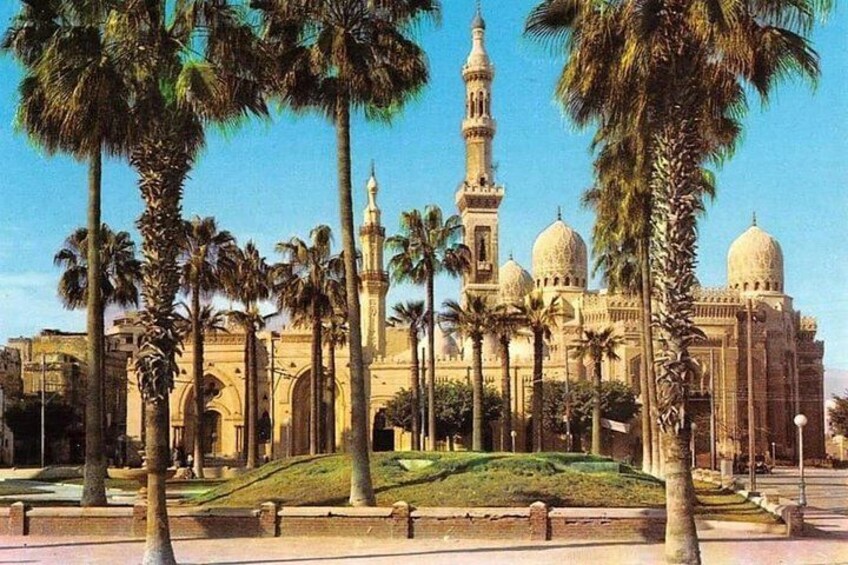 A mosque with domes and a minaret, surrounded by palm trees. 3