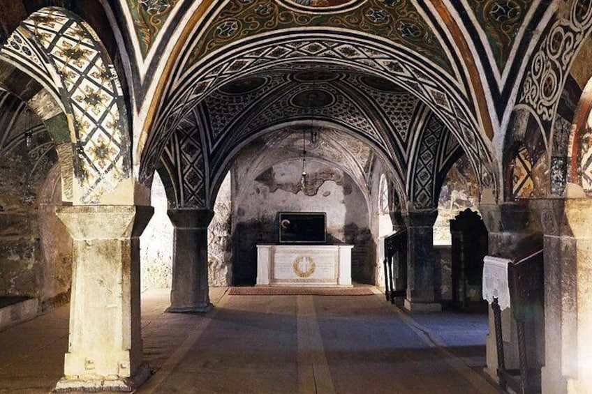 An interior with arched ceilings and a central altar. 5