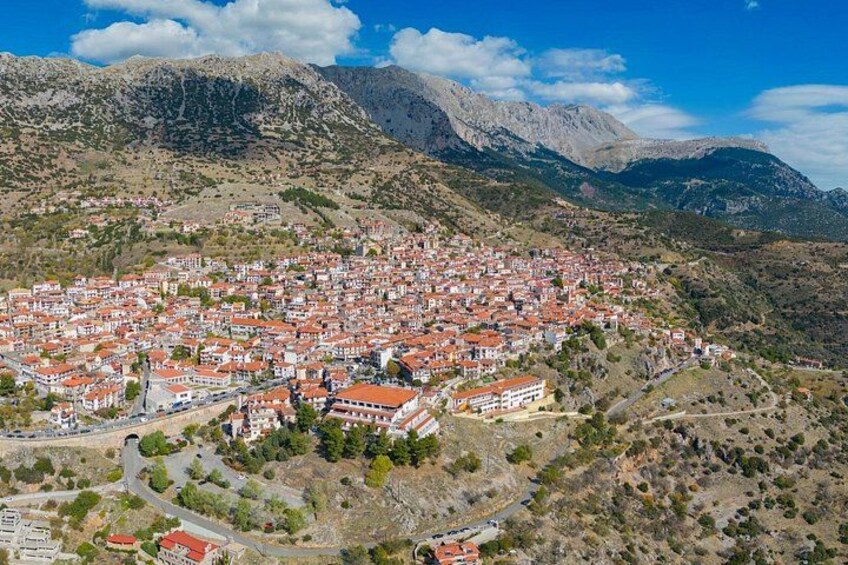 A town with red-roofed buildings nestled in a mountainous area. 2