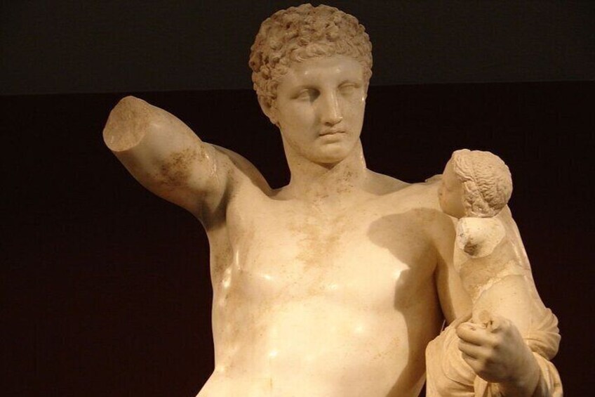 A marble statue of a male figure holding a child. 5