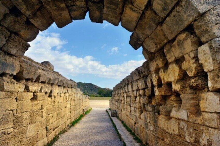 An ancient stone pathway flanked by high walls, leading to a distant hill. 2