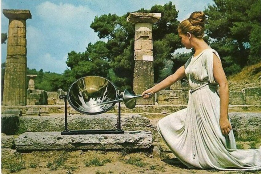 A woman in a white dress near ancient ruins with a large mirror. 1