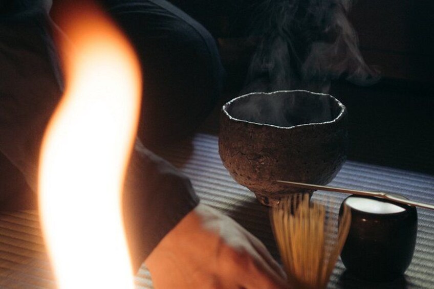 A lit candle, a bowl, and a cup on a table. 2