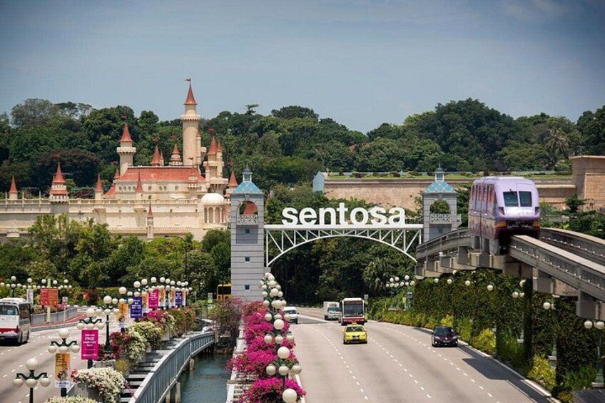 Un puente con un tren, un edificio parecido a un castillo y una carretera con vehículos. 1