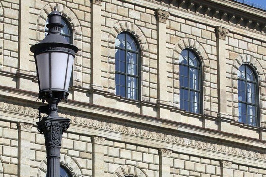 A building with arched windows and a street lamp. 2