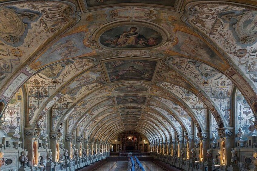 An ornate hallway with a series of arches and statues. 3