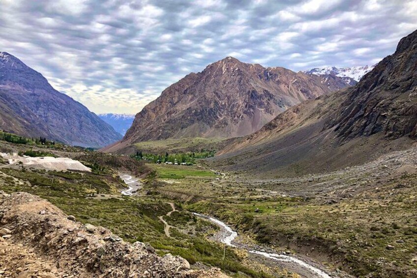 A mountainous landscape with a river, rocky terrain, and a clear sky. 2