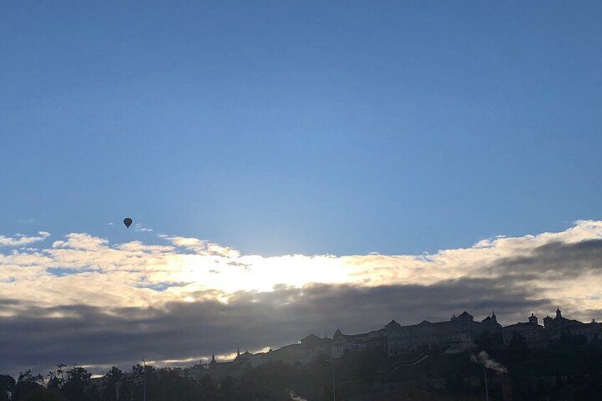 En varmluftsballong på himlen ovanför en stad med byggnader. 2