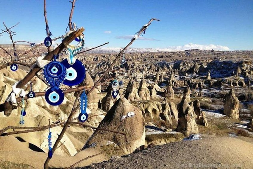 A landscape with unique rock formations and a tree with blue decorations. 4