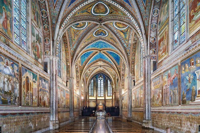 A cathedral interior with high vaulted ceilings, detailed frescoes, and a central aisle leading to an altar. 5