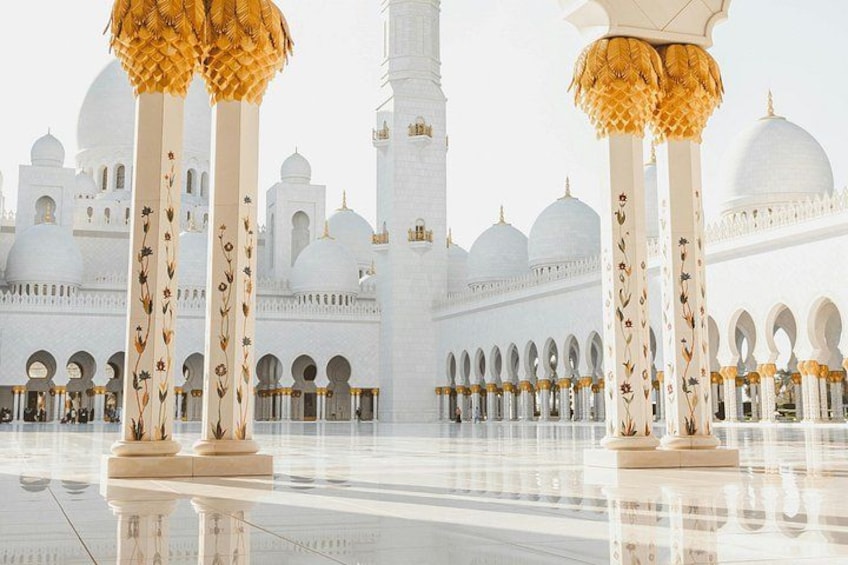 Une mosquée blanche aux accents dorés et aux imposantes colonnes décoratives. 3