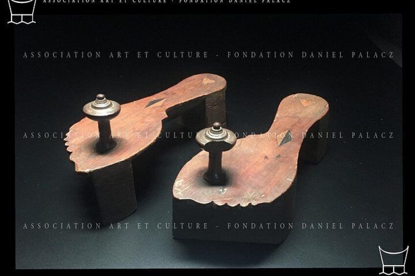 Two wooden sculptures with metal tops, displayed on a dark surface. 3