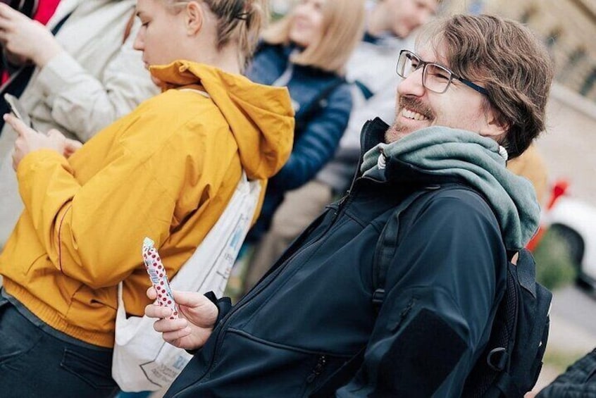 A group of people standing outdoors, some holding phones. 5
