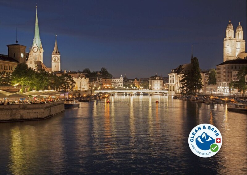 A nighttime cityscape with a river, illuminated buildings, and a prominent church spire. 2