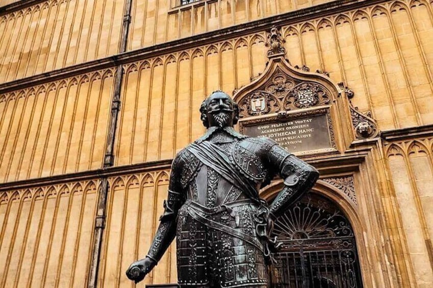 A statue of a man in armor in front of a building with ornate architecture. 1